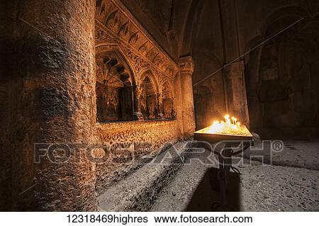 Stock Photograph - Lit candles in the Church in the rock erected by the Proshian family in Geghard Monastery, Azat Valley; Kotayk, Armenia. Fotosearch