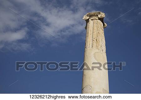 Stock Photograph - Low angle view of a column against a blue sky with cloud, Beit Shearim National Park; Beit Shean, North District, Israel. Fotosearch