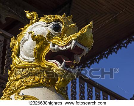 Stock Photograph - Low angle view of a traditional Asian white and gold sculpture in animal likeness; Tambon Mae Chan, Chang Wat Chiang Rai, Thailand. Fotosearch