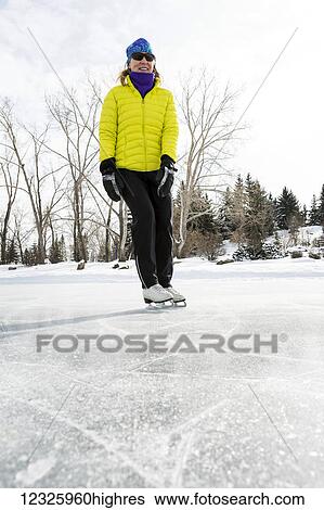 Low angle view of a woman skating on a frozen pond; Calgary, Alberta, Canada View Large Photo Image Stock Photograph - Low angle view of a woman skating on a frozen pond; Calgary, Alberta, Canada. Fotosearch