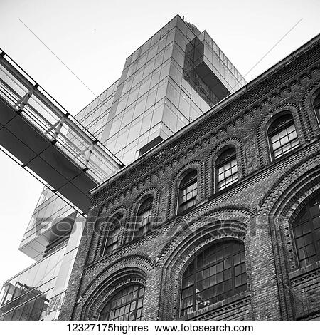 Stock Photograph - Low angle view of an old brick building in the foreground and a modern glass skyscraper in the background; Toronto, Ontario, Canada. Fotosearch