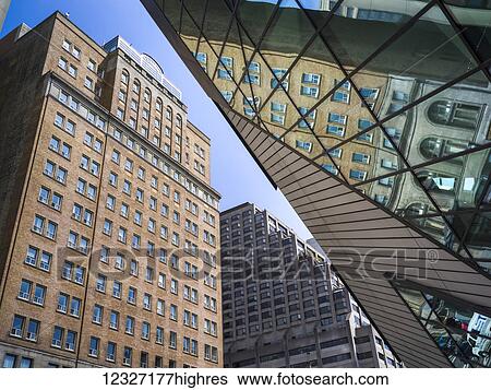 Stock Photograph - Low angle view of buildings and a reflection into the glass facade of the Royal Ontario Museum; Toronto, Ontario, Canada. Fotosearch