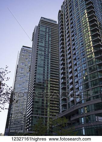 Stock Photograph - Low angle view of condominium tower in a row against a blue sky; Toronto, Ontario, Canada. Fotosearch