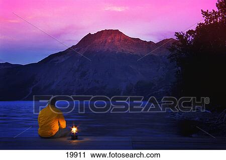 Stock Image - Man On Dock At Dusk. Fotosearch
