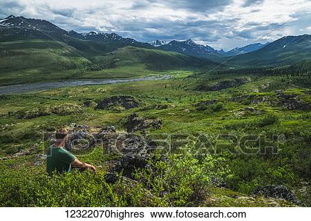 Man sitting overlooking the Klondike Valley along the Dempster Highway; Yukon, Canada View Large Photo Image Stock Photograph - Man sitting overlooking the Klondike Valley along the Dempster Highway; Yukon, Canada. Fotosearch