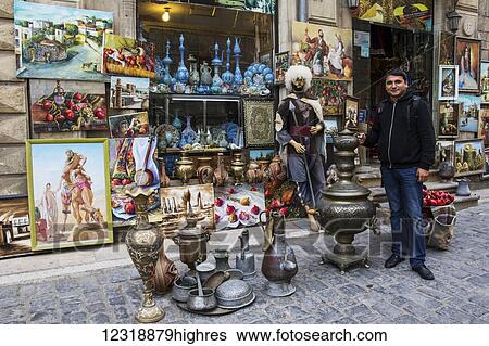 Man standing by objects for sale in a souvenir store; Baku, Azerbaijan View Large Photo Image Stock Photograph - Man standing by objects for sale in a souvenir store; Baku, Azerbaijan. Fotosearch