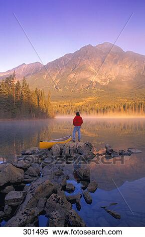 Stock Photography - Man with canoe Pyramid Lake Jasper National park Alberta Canada. Fotosearch