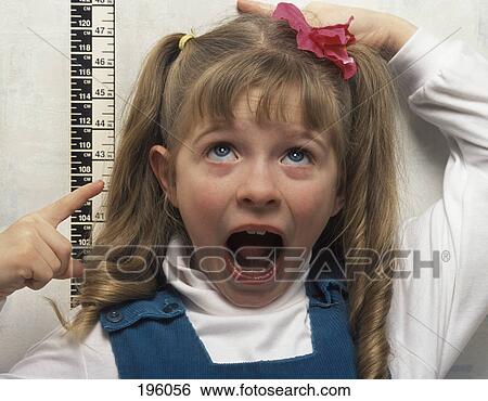 Measuring girl's height in doctor's office View Large Photo Image Stock Photograph - Measuring girl's height in doctor's office. Fotosearch