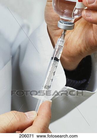 Medical personnel drawing injection from vial View Large Photo Image Stock Image - Medical personnel drawing injection from vial. Fotosearch