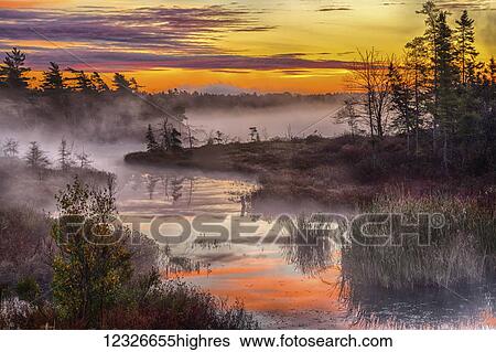 Stock Photograph - Morning mists rises off Rocky Lake; Bedford, Nova Scotia, Canada. Fotosearch
