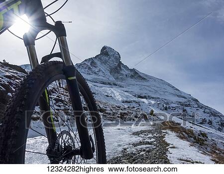Stock Photograph - Mountain biking in the Pennine Alps with a view of the Matterhorn, near Zermatt; Valais, Switzerland. Fotosearch