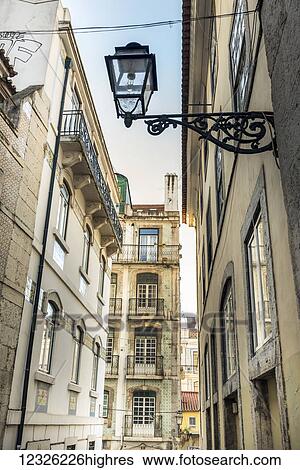 Stock Photograph - Narrow street lined with buildings; Lisbon, Portugal. Fotosearch