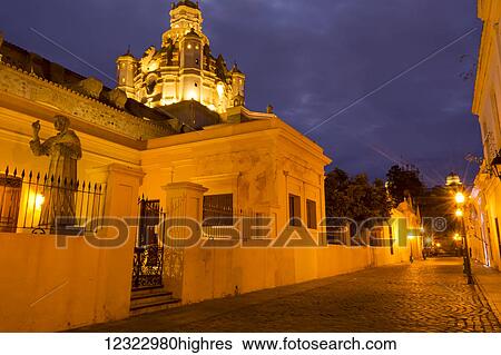 Stock Photograph - Night scene of a side street of paving stones in a South American town; Cordoba, Cordoba Province, Argentina. Fotosearch