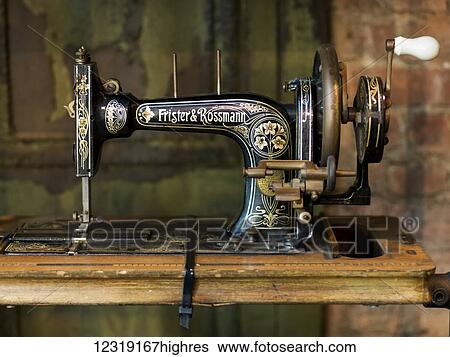 Stock Photograph - Old sewing machine on a wooden table, Lower Manhattan, Soho; New York City, New York, United States of America. Fotosearch