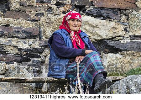 Old Svan woman sitting by her house in Chazhashi village; Ushguli, Samegrelo-Zemo Svaneti, Georgia View Large Photo Image Stock Photograph - Old Svan woman sitting by her house in Chazhashi village; Ushguli, Samegrelo-Zemo Svaneti, Georgia. Fotosearch
