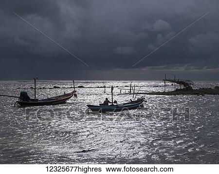 Ominous storm clouds over the Gulf of Thailand with small fishing boats in the water off the shore; Ko Samui, Chang Wat Surat Thani, Thailand View Large Photo Image Stock Photograph - Ominous storm clouds over the Gulf of Thailand with small fishing boats in the water off the shore; Ko Samui, Chang Wat Surat Thani, Thailand. Fotosearch