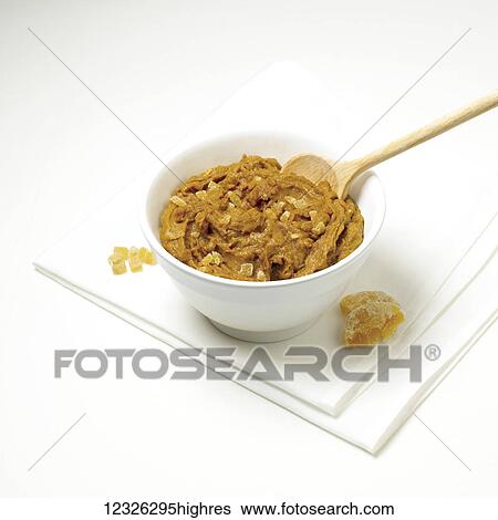 Stock Photograph - Peanut butter cookie dough in a bowl with a wooden spoon on a white background. Fotosearch