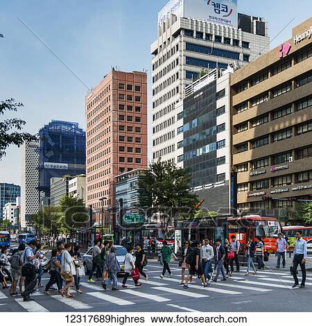 Stock Photograph - Pedestrians cross a busy street on a crosswalk; Seoul, South Korea. Fotosearch