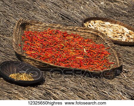 Stock Photograph - Peppers and grains drying in baskets on thatching; Tambon Mae Salong Nok, Chang Wat Chiang Rai, Thailand. Fotosearch