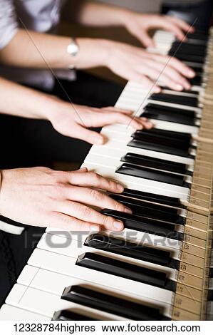 Stock Photograph - Playing a duet on the piano; Alaska, United States of America. Fotosearch
