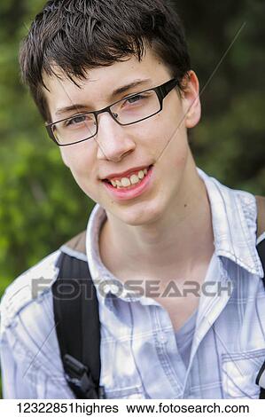 Stock Photograph - Portrait of a boy with eyeglasses and backpack straps; Washington, United States of America. Fotosearch
