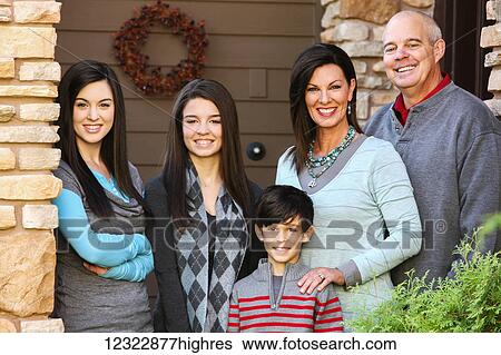 Stock Photograph - Portrait of a family with three children standing at the door of their house; Oregon, United States of America. Fotosearch