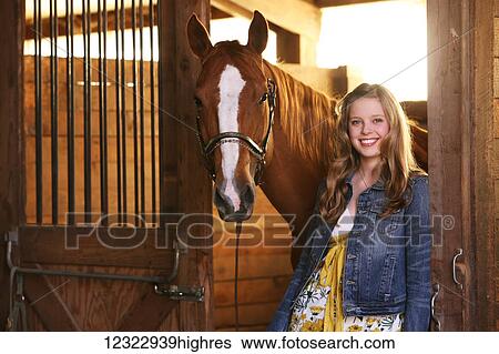 Portrait of a girl standing in a stable with her horse; Oregon, United States of America View Large Photo Image Stock Photograph - Portrait of a girl standing in a stable with her horse; Oregon, United States of America. Fotosearch