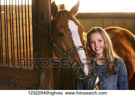 Portrait of a girl standing in a stable with her horse; Oregon, United States of America View Large Photo Image Stock Photograph - Portrait of a girl standing in a stable with her horse; Oregon, United States of America. Fotosearch