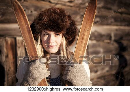 Portrait of a girl wearing a fur hat and holding a pair of wooden skis at a log cabin; Homer, Alaska, United States of America View Large Photo Image Stock Photograph - Portrait of a girl wearing a fur hat and holding a pair of wooden skis at a log cabin; Homer, Alaska, United States of America. Fotosearch