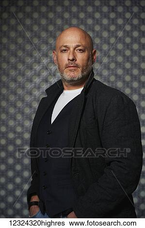 Stock Photograph - Portrait of a middle aged man against a patterned background; Ontario, Canada. Fotosearch