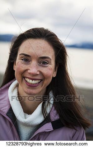 Portrait of a smiling woman with long brunette hair; Homer, Alaska, United States of America View Large Photo Image Stock Photograph - Portrait of a smiling woman with long brunette hair; Homer, Alaska, United States of America. Fotosearch