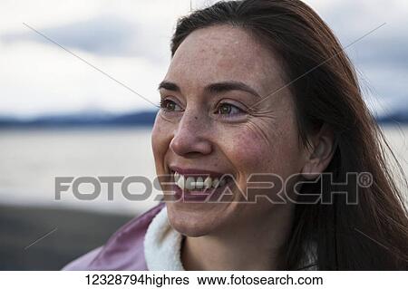 Portrait of a smiling woman with long brunette hair; Homer, Alaska, United States of America View Large Photo Image Stock Photograph - Portrait of a smiling woman with long brunette hair; Homer, Alaska, United States of America. Fotosearch