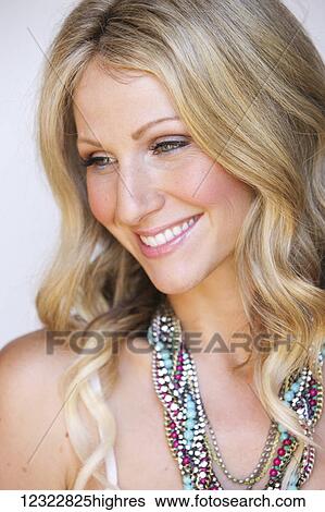 Portrait of a woman with long blond hair and a colourful beaded necklace against a white background; Oregon, United States of America View Large Photo Image Stock Photograph - Portrait of a woman with long blond hair and a colourful beaded necklace against a white background; Oregon, United States of America. Fotosearch