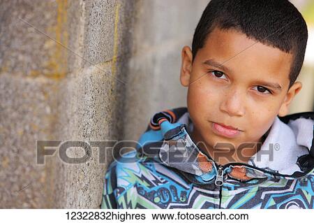 Portrait of a young boy standing against a concrete wall; Oregon, United States of America View Large Photo Image Stock Photograph - Portrait of a young boy standing against a concrete wall; Oregon, United States of America. Fotosearch