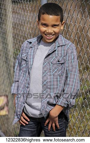 Portrait of a young boy standing against a chain link fence; Oregon, United States of America View Large Photo Image Stock Photograph - Portrait of a young boy standing against a chain link fence; Oregon, United States of America. Fotosearch