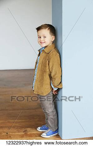 Portrait of a young boy standing against a blue painted wall; Oregon, United States of America View Large Photo Image Stock Photograph - Portrait of a young boy standing against a blue painted wall; Oregon, United States of America. Fotosearch