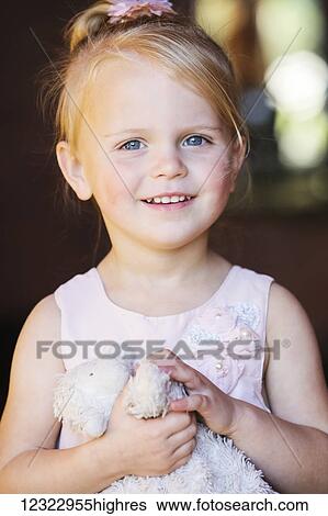 Stock Photograph - Portrait of a young girl holding her stuffed toy; Washington, United States of America. Fotosearch