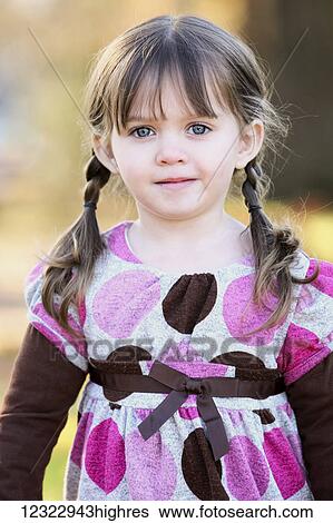Stock Photograph - Portrait of a young girl with brunette hair in braids and blue eyes; Oregon, United States of America. Fotosearch