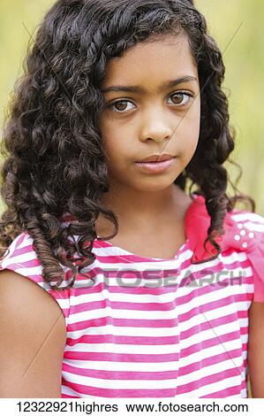 Stock Photograph - Portrait of a young girl with dark, curly hair and big brown eyes; Vancouver, Washington, United States of America. Fotosearch