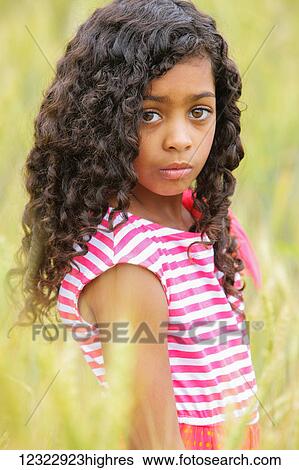 Stock Photograph - Portrait of a young girl with dark, curly hair and big brown eyes; Vancouver, Washington, United States of America. Fotosearch