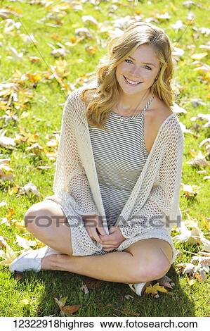 Portrait of a young woman sitting on the grass in autumn; Oregon, United States of America View Large Photo Image Stock Photograph - Portrait of a young woman sitting on the grass in autumn; Oregon, United States of America. Fotosearch