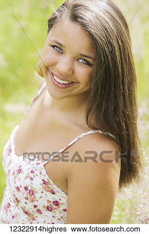 Stock Photograph - Portrait of a young woman with long, brown hair and bright blue eyes; Oregon, United States of America. Fotosearch