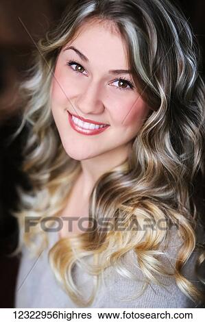 Stock Photograph - Portrait of a young woman with long blond curly hair; Oregon, United States of America. Fotosearch