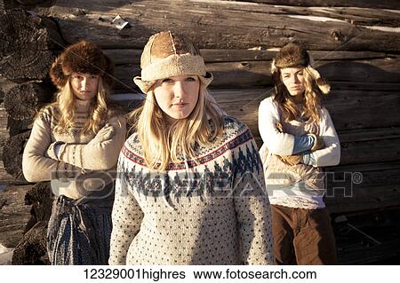 Portrait of three girls standing by a log cabin wearing fur hats; Homer, Alaska, United States of America View Large Photo Image Stock Photograph - Portrait of three girls standing by a log cabin wearing fur hats; Homer, Alaska, United States of America. Fotosearch