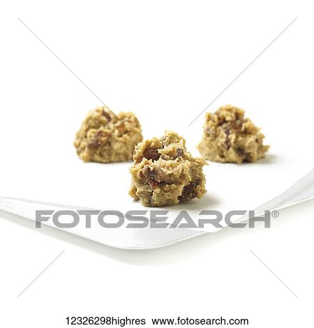 Raw cookie dough with dates and raisins formed on parchment paper on a white background View Large Photo Image Stock Photograph - Raw cookie dough with dates and raisins formed on parchment paper on a white background. Fotosearch