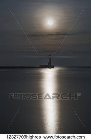 Roker Lighthouse at the end of a pier under a bright full moon reflecting on tranquil water; Sunderland, Tyne and Wear, England View Large Photo Image Stock Photograph - Roker Lighthouse at the end of a pier under a bright full moon reflecting on tranquil water; Sunderland, Tyne and Wear, England. Fotosearch