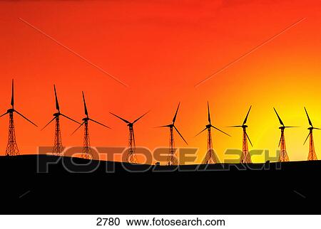 Stock Image - Row of wind turbines and sunset. Fotosearch