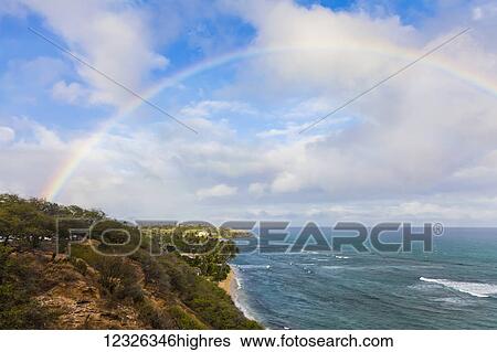 Stock Photograph - Scenic lookout point of Diamond Head Beach and Black Point Kahala with a full rainbow overhead; Honolulu, Oahu, Hawaii, United States of America. Fotosearch