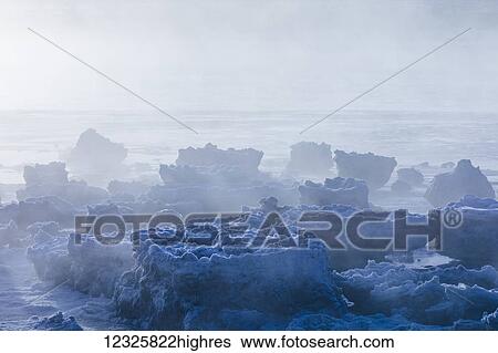 Stock Photograph - Sea ice is shrouded in fog along Turnagain Arm in winter, South-central Alaska; Alaska, United States of America. Fotosearch