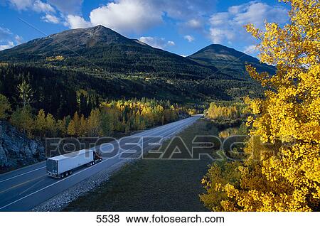 Semi truck on small two lane mountain highway in fall View Large Photo Image Stock Photo - Semi truck on small two lane mountain highway in fall. Fotosearch